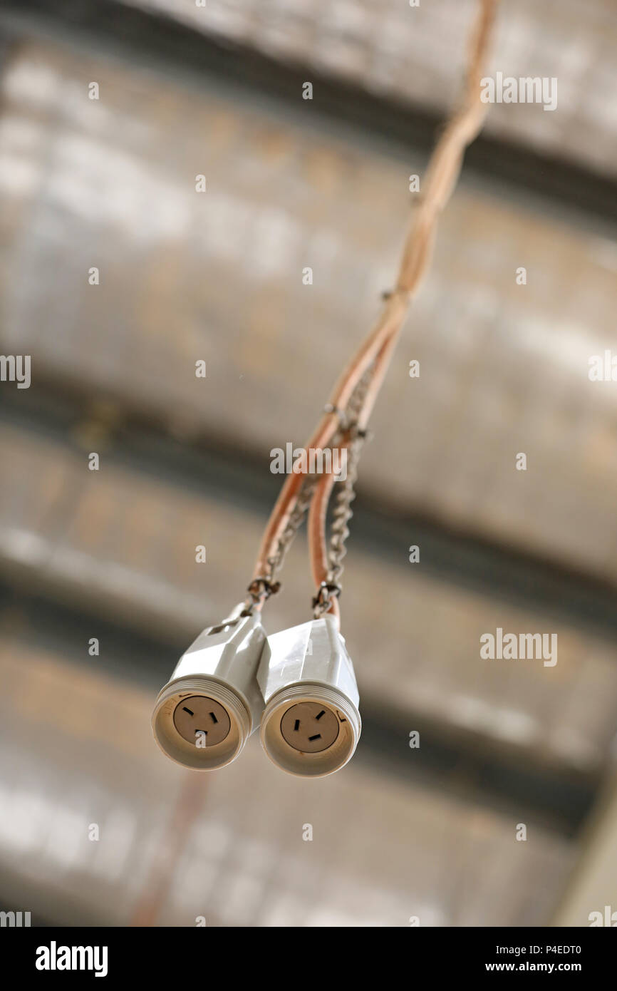 Une paire de prise de courant à 3 broches Câble cordon sur le fil suspendu  à un plafond d'usine toit. bloc d'alimentation. câblage électrique dans un  atelier Photo Stock - Alamy