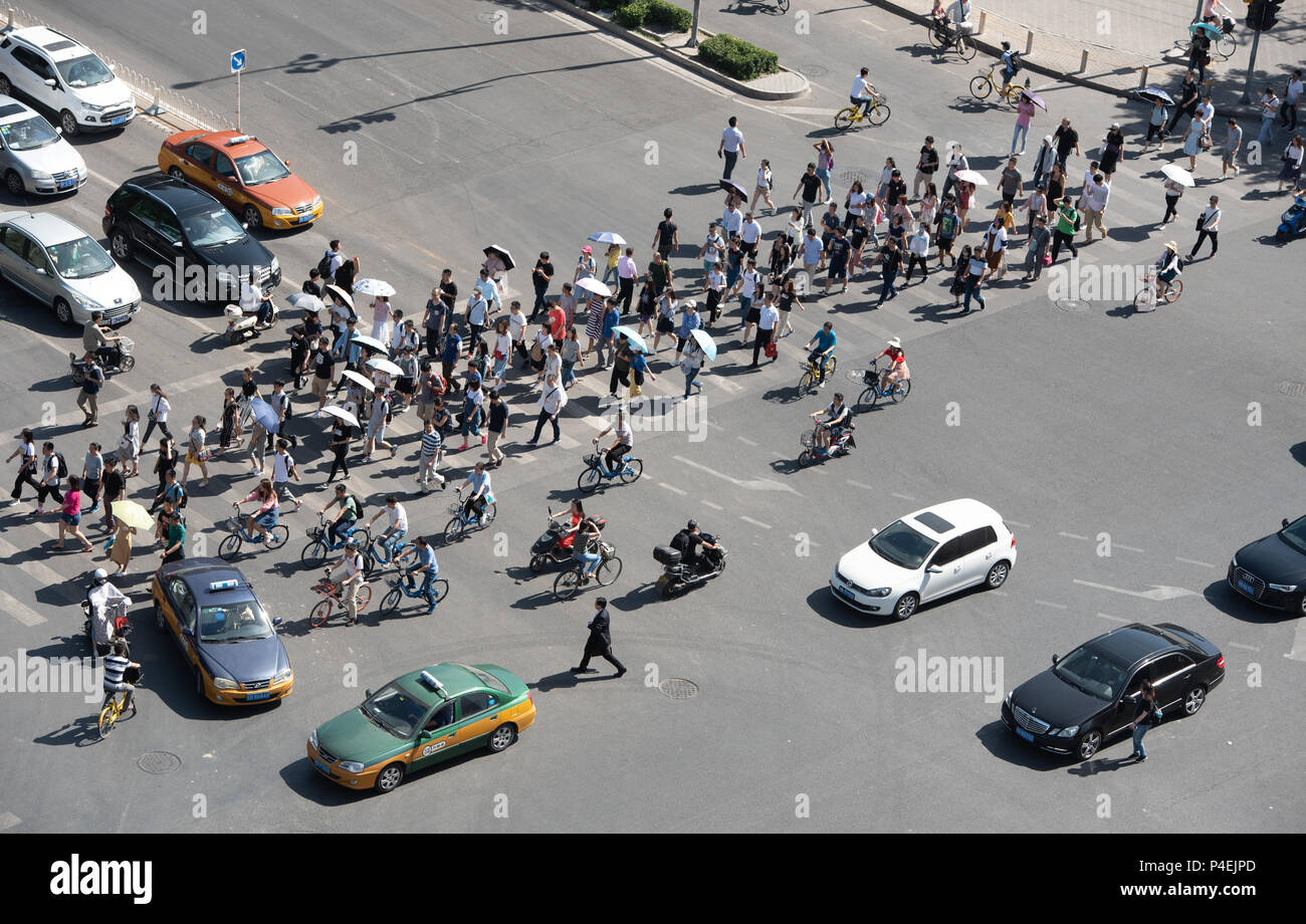 Beijing, Asie - 4 juin 2018 : Groupe de personnes traversant une avenue à fort trafic avec des voitures et des vélos dans la ville de Beijing en Chine Banque D'Images