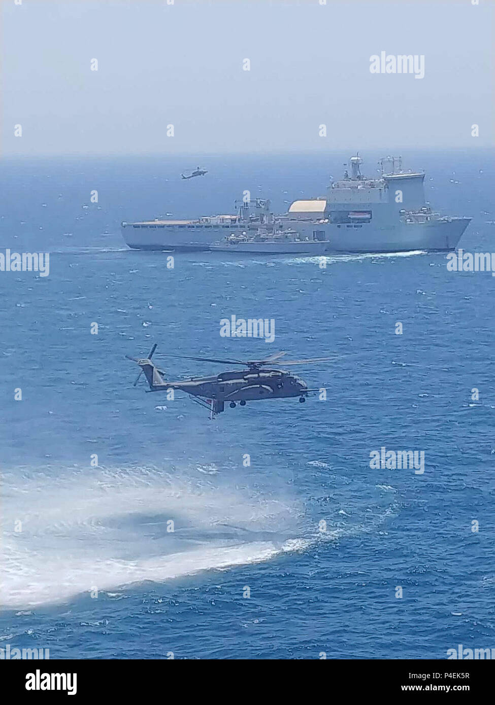 180617-N-NO146-0001 U.S. 5ÈME ZONE DES OPÉRATIONS DE LA FLOTTE (17 juin 2018) Un hélicoptère MH-53 Sea Dragon, attribué à 'la' Blackhawks de l'Escadron d'hélicoptères de la lutte contre les mines (HM), 15 téléskis un AQS-24B comme système de chasse aux mines destiné au chasseur de la Royal Navy HMS Middleton (M34) aux côtés de radeaux Royal Fleet Auxiliary landing ship dock de demandes La Baie de Cardigan (L3009) alors qu'un MH-60 Sea Hawk, affecté à l'Escadron d'hélicoptères de combat de la mer (HSC), repart avec 26 visiteurs distingués au cours de l'exercice de lutte contre les mines (MCMEX) 18-2. L'exercice bilatéral renforce la coopération mutuelle, la lutte contre les mines capabi Banque D'Images