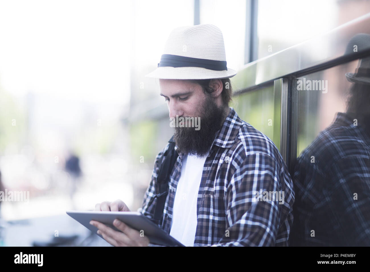 Homme assis à l'extérieur à l'aide d'une tablette numérique Banque D'Images