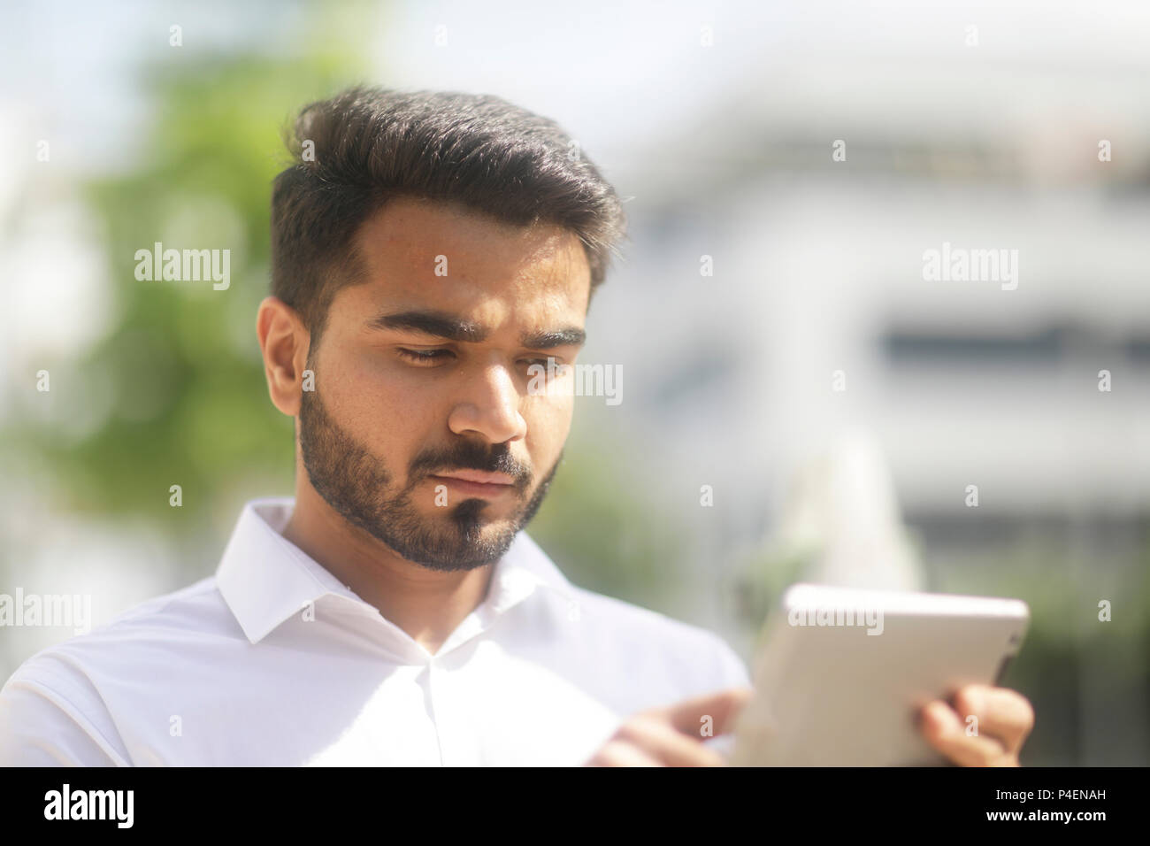 Homme debout à l'extérieur à l'aide d'une tablette numérique Banque D'Images