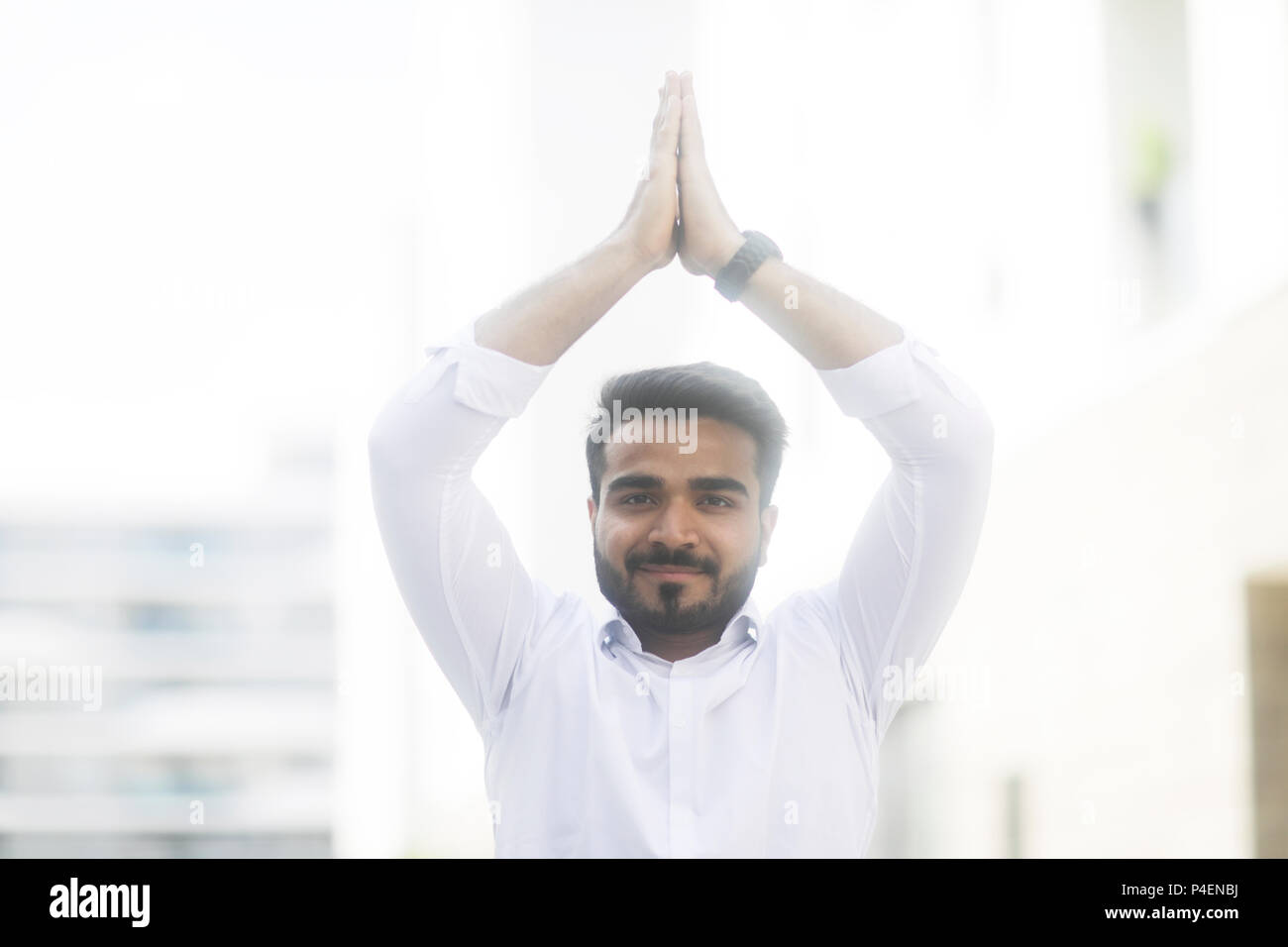 Businessman standing outdoors doing yoga Banque D'Images