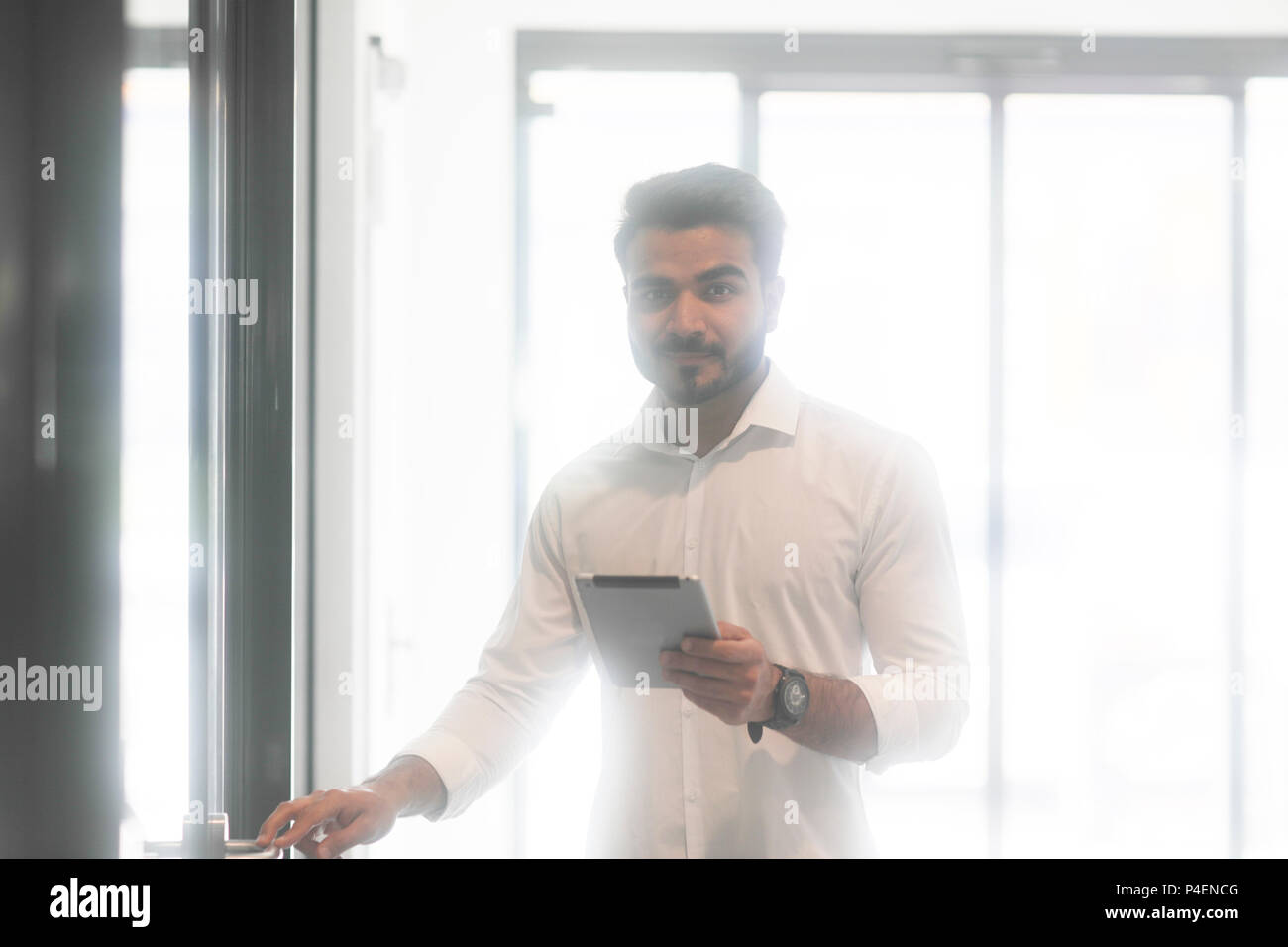 Homme debout dans un bureau à l'aide d'une tablette numérique Banque D'Images