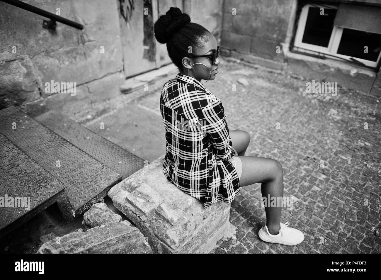 Le hip-hop african american girl sur des lunettes de soleil et des shorts jeans. Rue occasionnels fashion portrait de femme noire. Banque D'Images