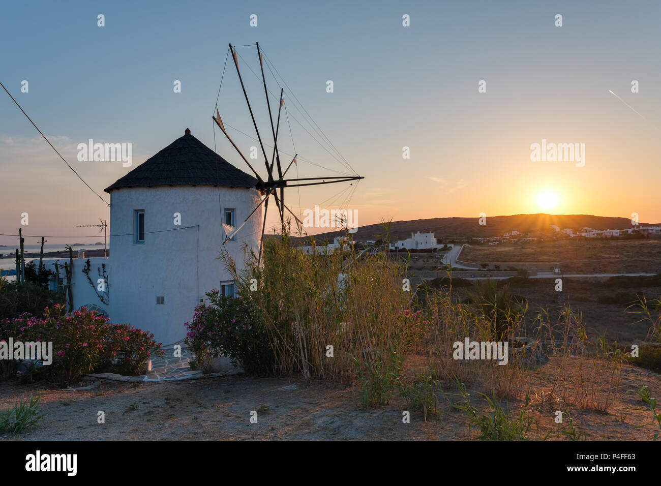 Moulin à vent traditionnel des cyclades au coucher du soleil sur l'île de Paros, Cyclades, Grèce Banque D'Images