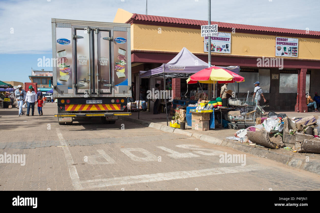 Rue ville africaine avec scène de rue informelles et de l'alimentation des camions de livraison de l'opérateur au centre commercial de Mahikeng, Afrique du Sud Banque D'Images
