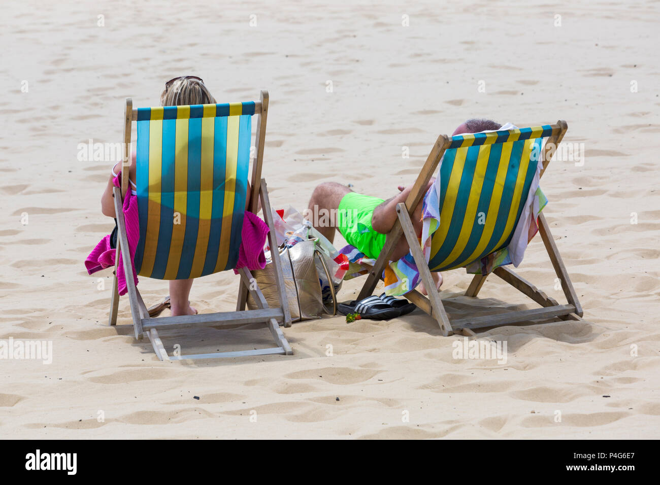 Bournemouth, Dorset, UK. 22 juin 2018. Météo France : belle chaude journée ensoleillée à plages de Bournemouth en tant que visiteurs, chef de la station pour profiter du soleil, comme la prévision est pour les températures d'augmenter. Dans deux transats sur la plage - Vue arrière, vue arrière. Credit : Carolyn Jenkins/Alamy Live News Banque D'Images