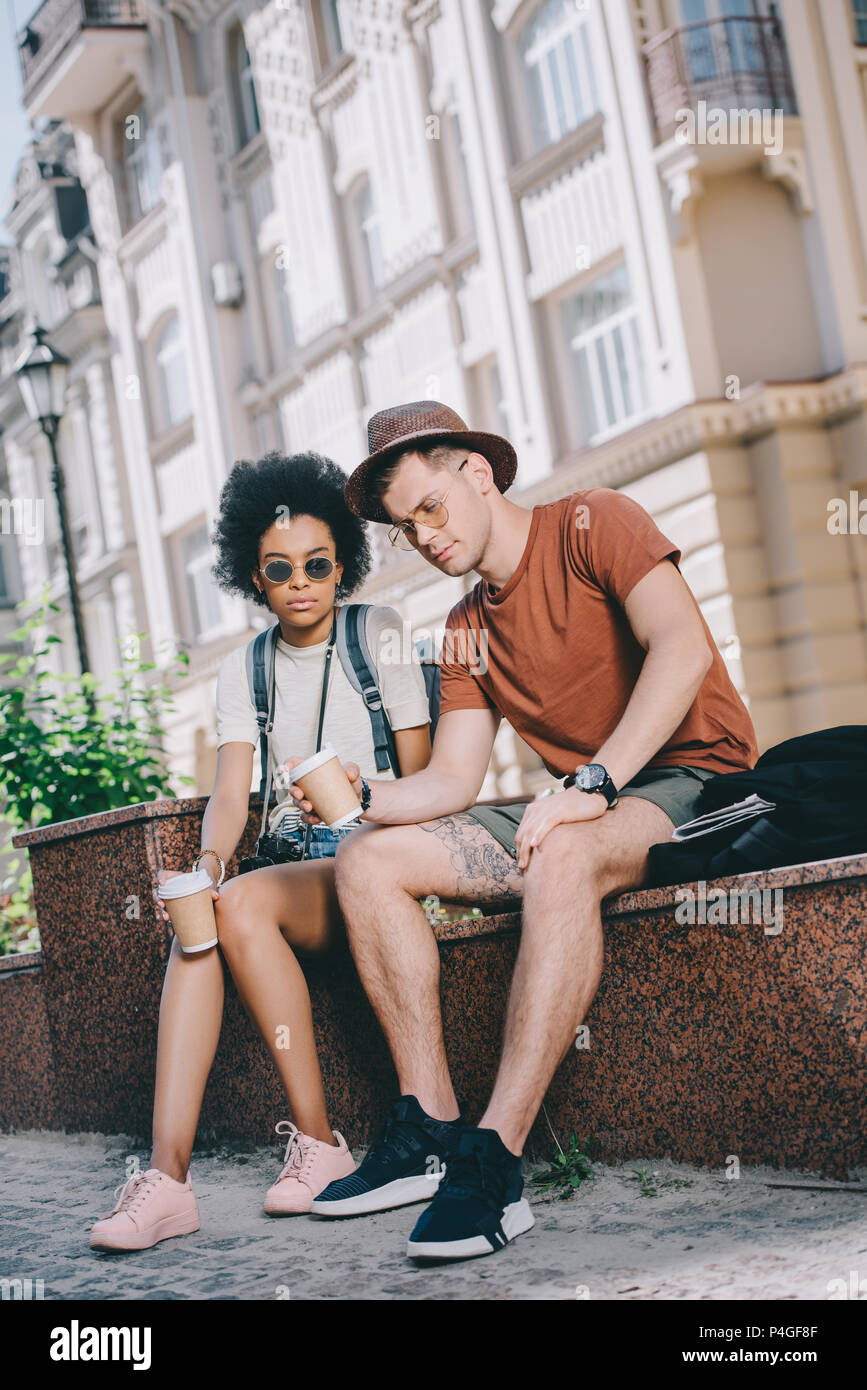 Couple de touristes fatigués assis avec des tasses de café Banque D'Images