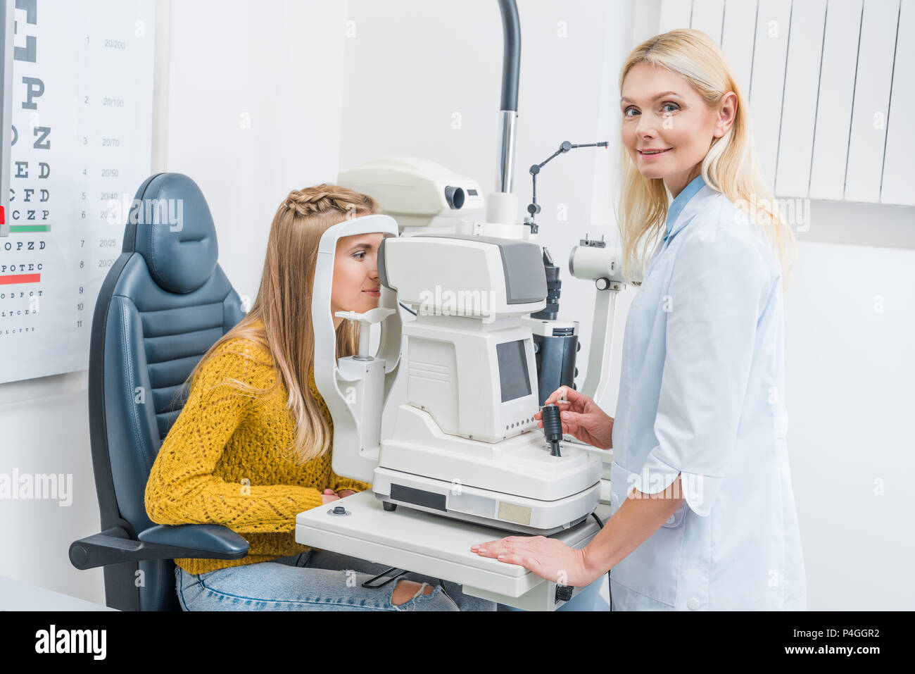 Les professionnels de l'examen de l'opticien par patient dans une clinique de la lampe à fente Banque D'Images