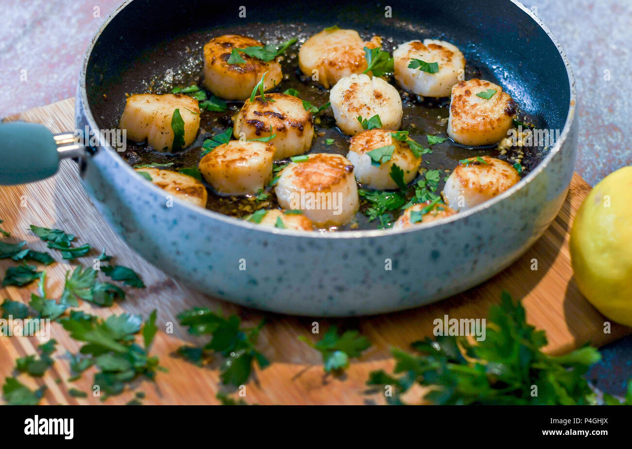 Saisir les pétoncles dans une poêle ; cuisine gastronomique fait maison Banque D'Images