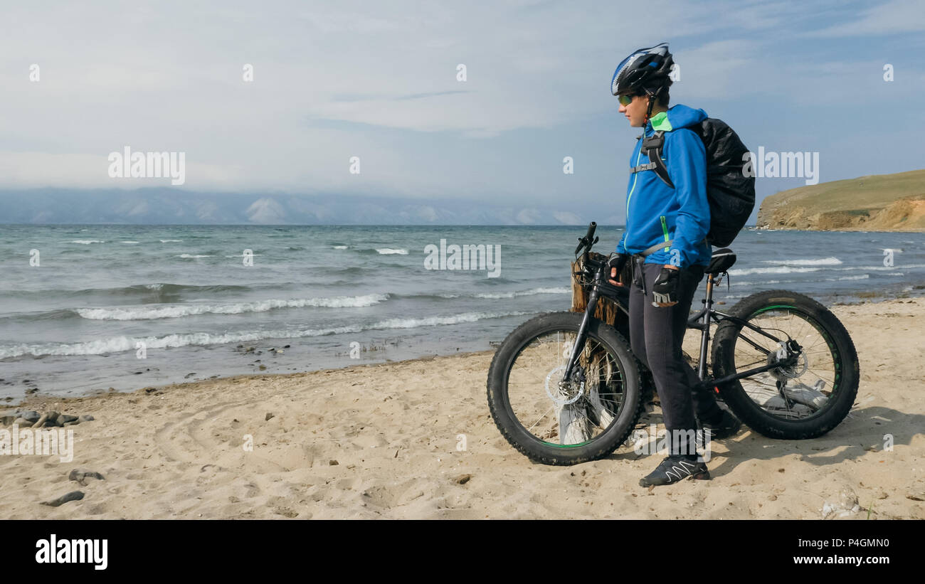 Appelé aussi fatbike vélo FAT ou FAT-pneu vélo dans la conduite en été sur  la plage. Le mec va tout droit sur la plage. Sur le sable sur un tel tour de