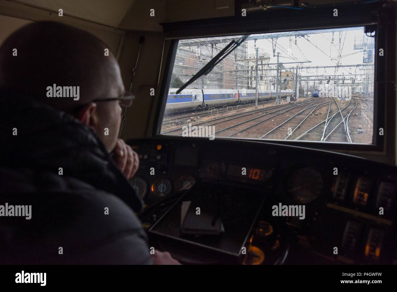 13 mars 2018 - Paris, France : un travailleur ferroviaire française conduit un train entre Paris et la banlieue de Paris. Les Français sont en train de préparer une grande manifestation de rue le 22 mars pour protester contre le Président Emmanuel MacronÕs des plans de réforme du national français Gare SNCF. Dans le cadre de leur mouvement d'opposition, les travailleurs ferroviaires envisagent également d'une grève des transports. Un cheminot un train conduit en banlieue parisienne, quelques jours avant le debut du mouvement de greve. Banque D'Images