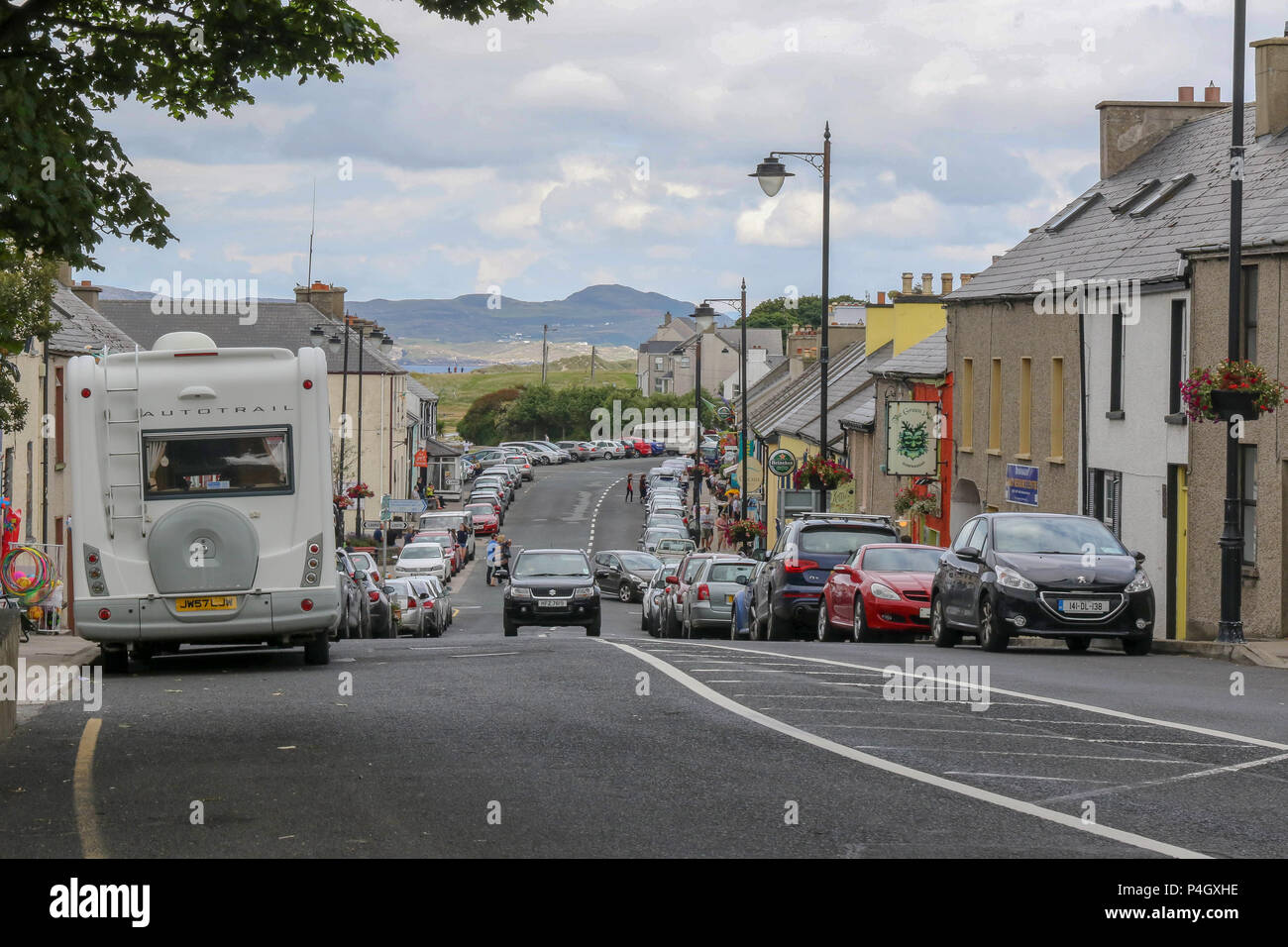 Les voitures et les boutiques dans la rue principale à Dunfanaghy - un village populaire pour les touristes, dans le comté de Donegal, Irlande. Banque D'Images