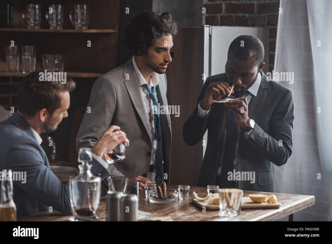 Affaires multiethniques de boire du whisky et à prendre de la drogue à l'intérieur Banque D'Images