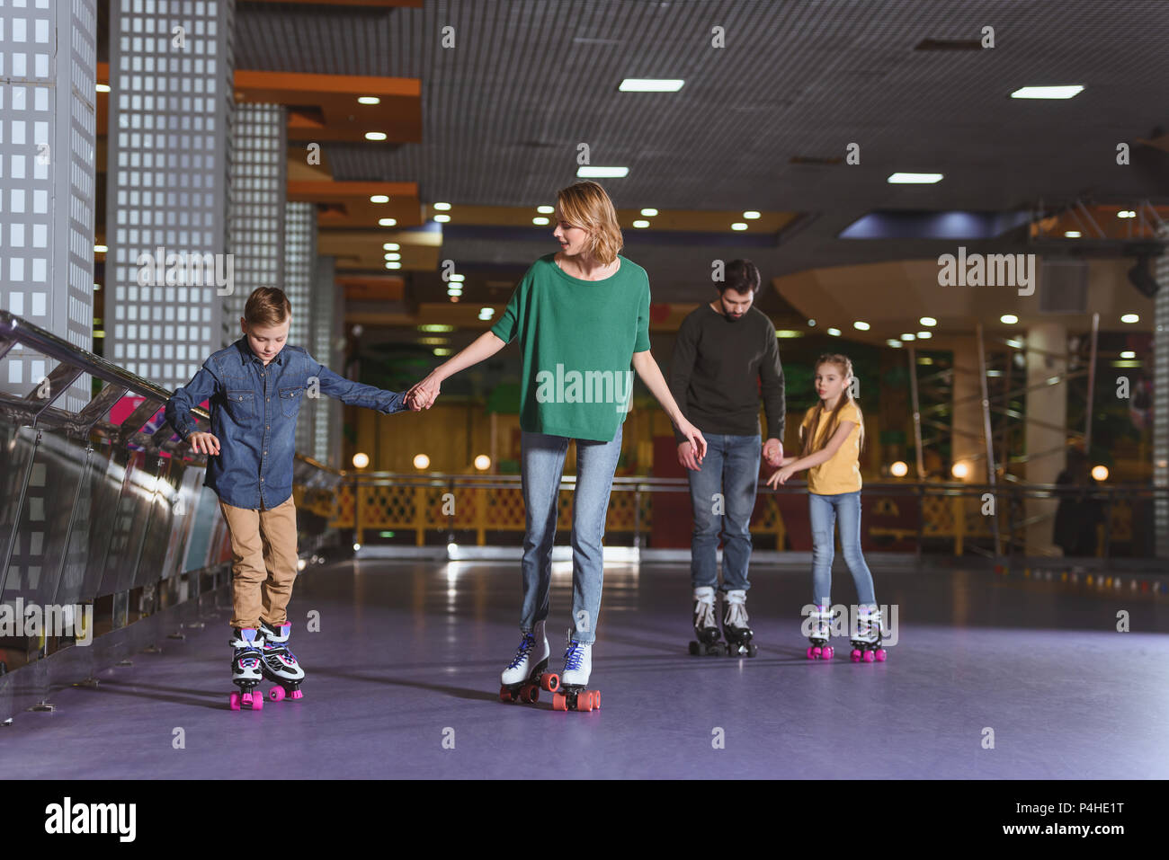 Parents et enfants patinage sur roller rink ensemble Banque D'Images