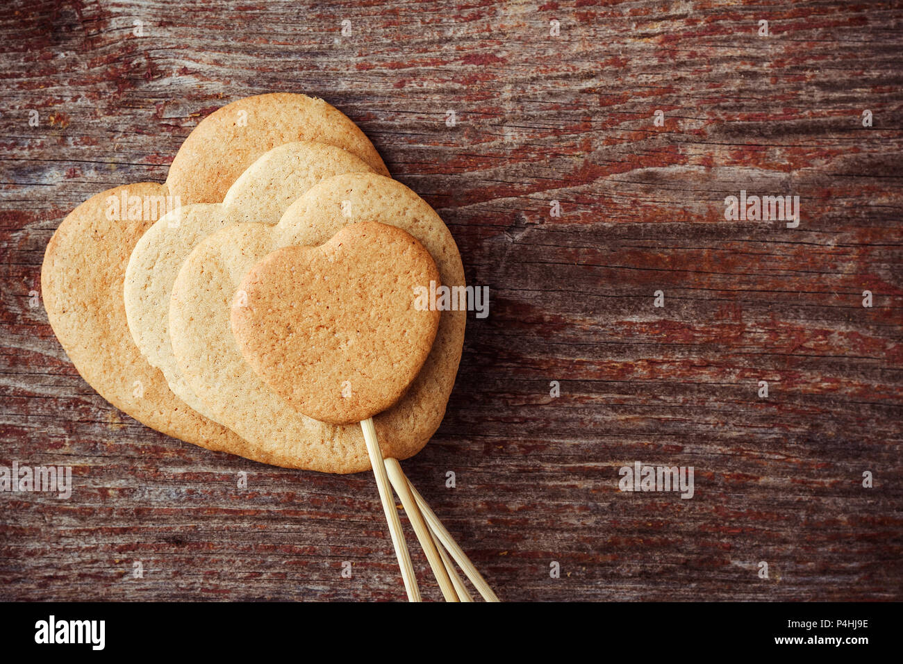 Ginger cookies sur un bâton en forme de cœur sur un fond de bois. Top View with copy space Banque D'Images