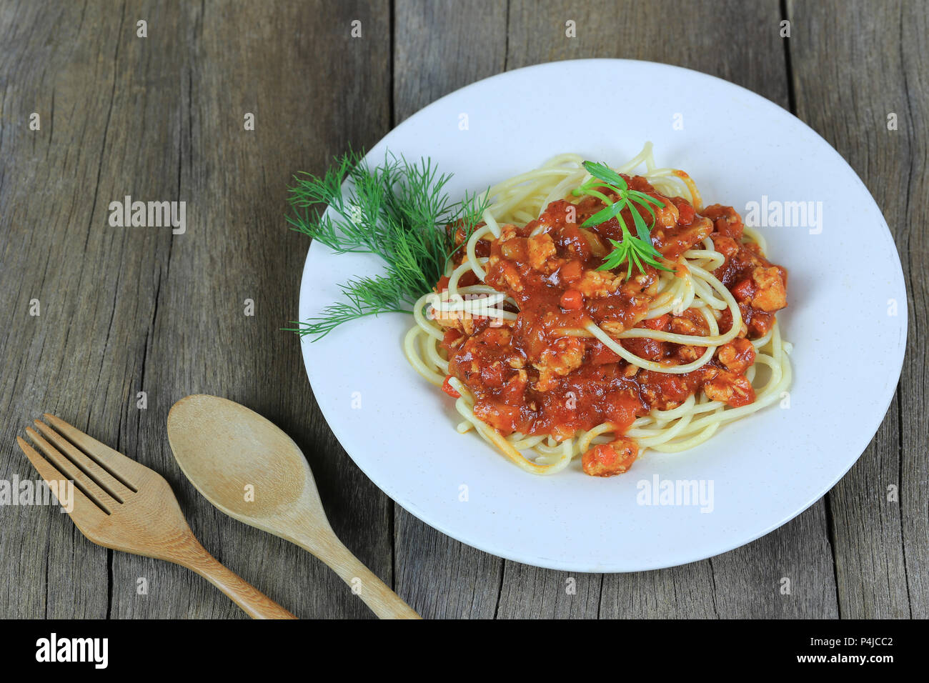 Spaghetti à la sauce tomate dans un plat blanc sur un sol en parquet et d'arrière-plan ont copie espace dans la notion de manger de la bonne nourriture est les soins de santé. Banque D'Images