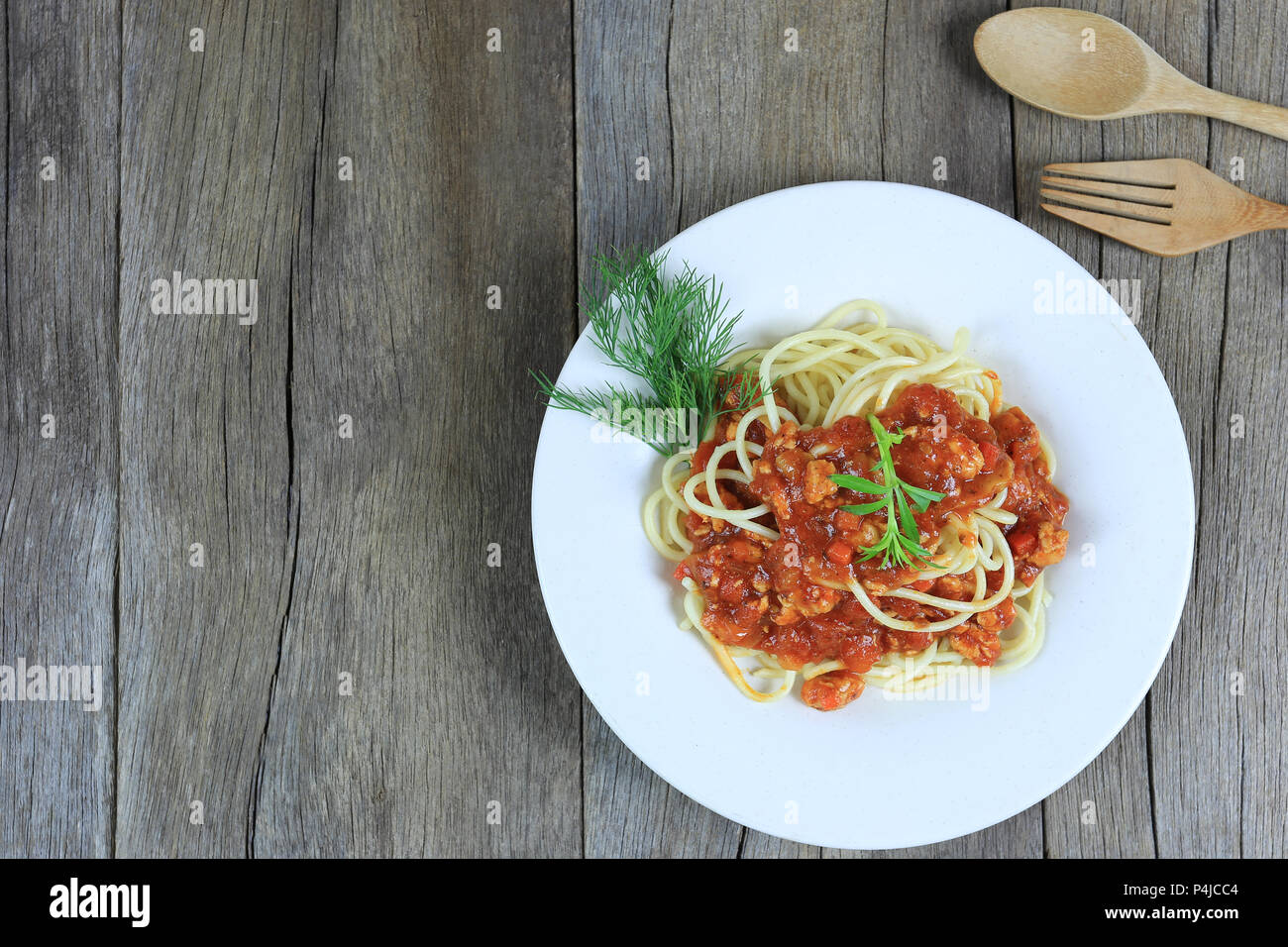 Spaghetti à la sauce tomate dans un plat blanc sur un sol en parquet et d'arrière-plan ont copie espace dans la notion de manger de la bonne nourriture est les soins de santé. Banque D'Images