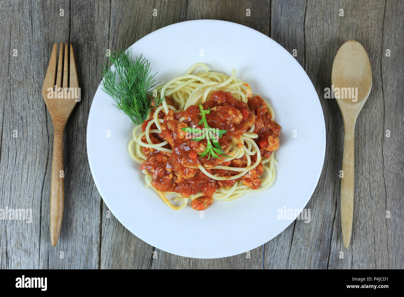 Spaghetti à la sauce tomate dans un plat blanc sur un sol en parquet et d'arrière-plan ont copie espace dans la notion de manger de la bonne nourriture est les soins de santé. Banque D'Images