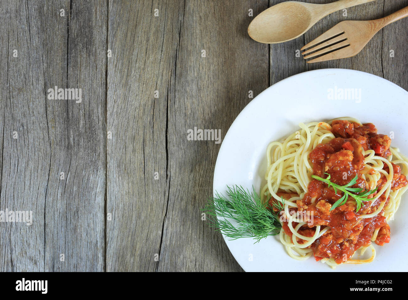 Spaghetti à la sauce tomate dans un plat blanc sur un sol en parquet et d'arrière-plan ont copie espace dans la notion de manger de la bonne nourriture est les soins de santé. Banque D'Images