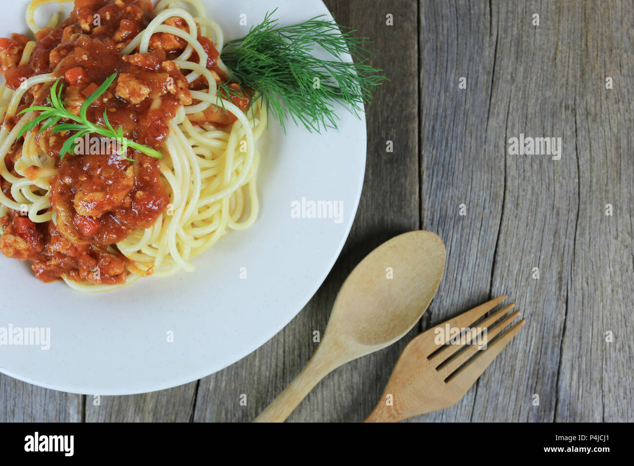 Spaghetti à la sauce tomate dans un plat blanc sur un sol en parquet et d'arrière-plan ont copie espace dans la notion de manger de la bonne nourriture est les soins de santé. Banque D'Images