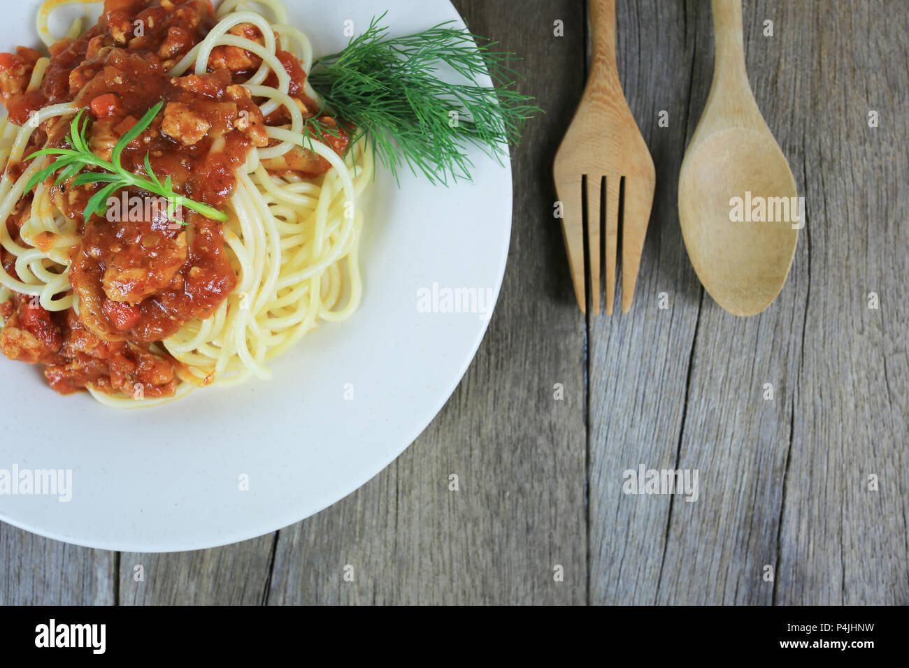 Spaghetti à la sauce tomate dans un plat blanc sur un sol en parquet et d'arrière-plan ont copie espace dans la notion de manger de la bonne nourriture est les soins de santé. Banque D'Images