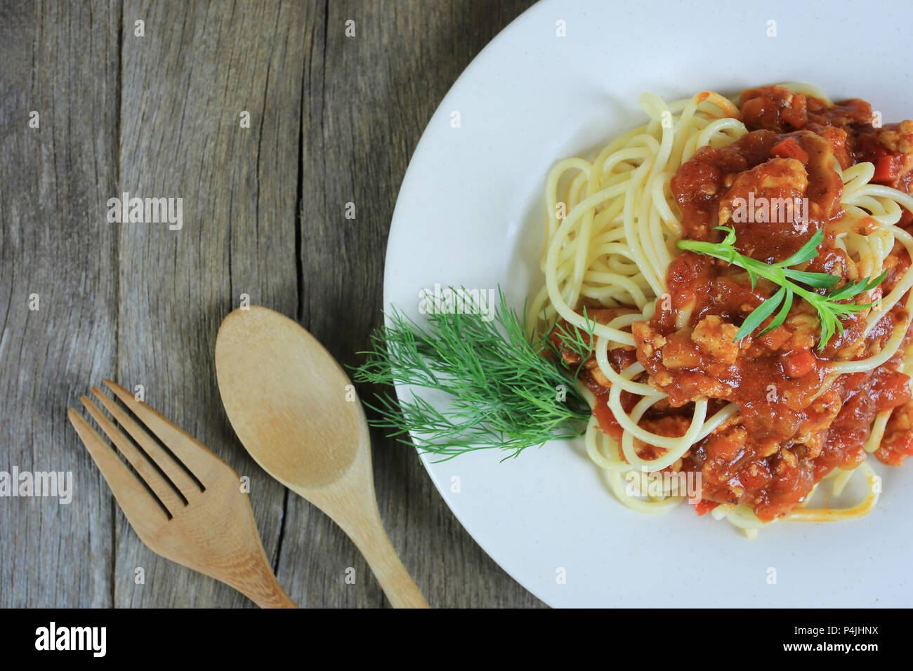 Spaghetti à la sauce tomate dans un plat blanc sur un sol en parquet et d'arrière-plan ont copie espace dans la notion de manger de la bonne nourriture est les soins de santé. Banque D'Images