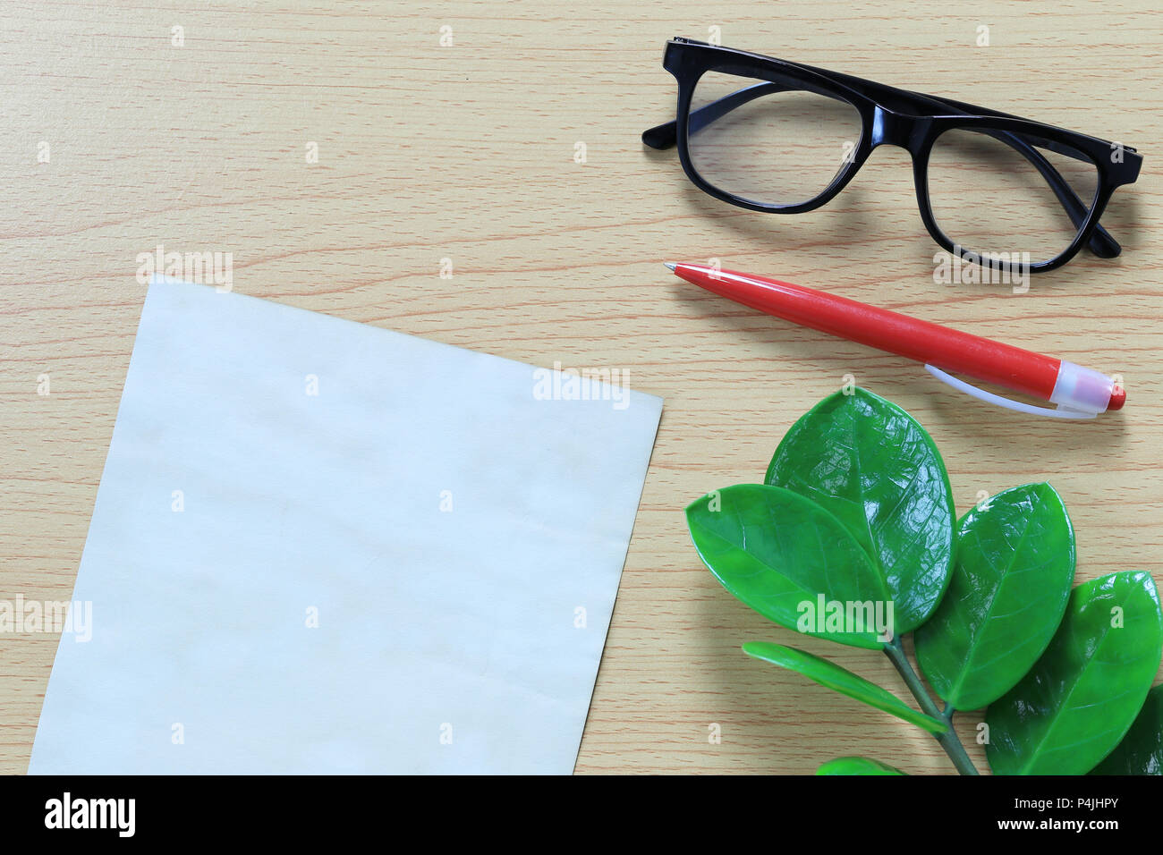 Note de papier vierge et de lunettes placé sur un plancher en bois marron pour la conception dans votre travail concept. Banque D'Images