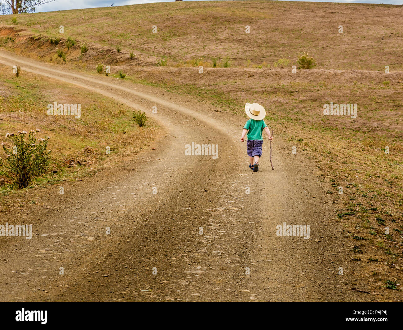 Petit garçon marcher seul dans la campagne, dans la haute vallée de l'Hunter, NSW, Australie. Banque D'Images