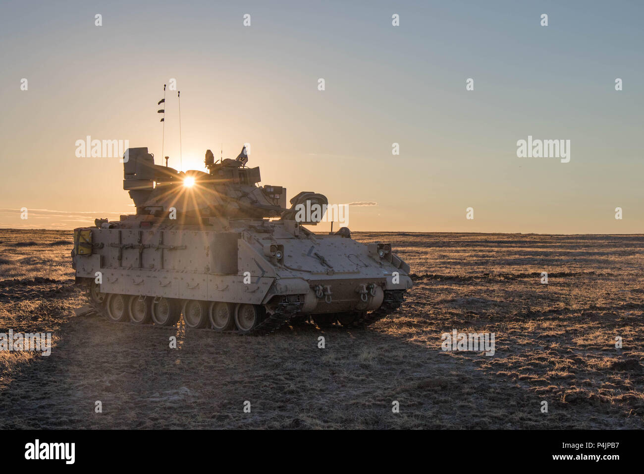 Le soleil se couche derrière un véhicule de combat Bradley comme la compagnie Bravo, 1-163ème bataillon interarmes, Montana Army National Guard en attendant l'arrivée d'une nuit d'itération pour commencer de l'Orchard Centre de formation, New York le 19 juin 2018. (U.S. Photo de l'armée par la CPS. Michael Hunnisett) Banque D'Images