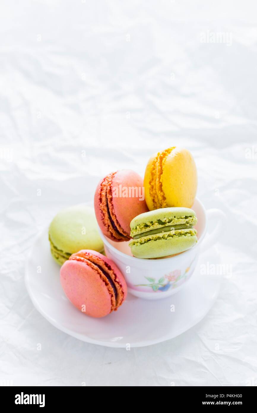 Assortiment de macarons colorés dans une tasse de thé Banque D'Images