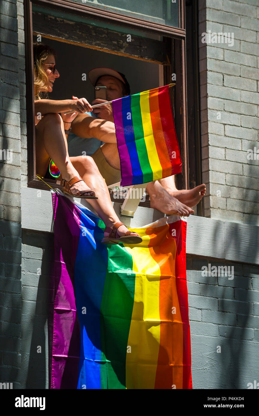NEW YORK - 25 juin 2017 : vague de drapeaux arc-en-ciel partisans un appartement d''une fenêtre donnant sur la Gay Pride Parade annuelle à Greenwich Village Banque D'Images