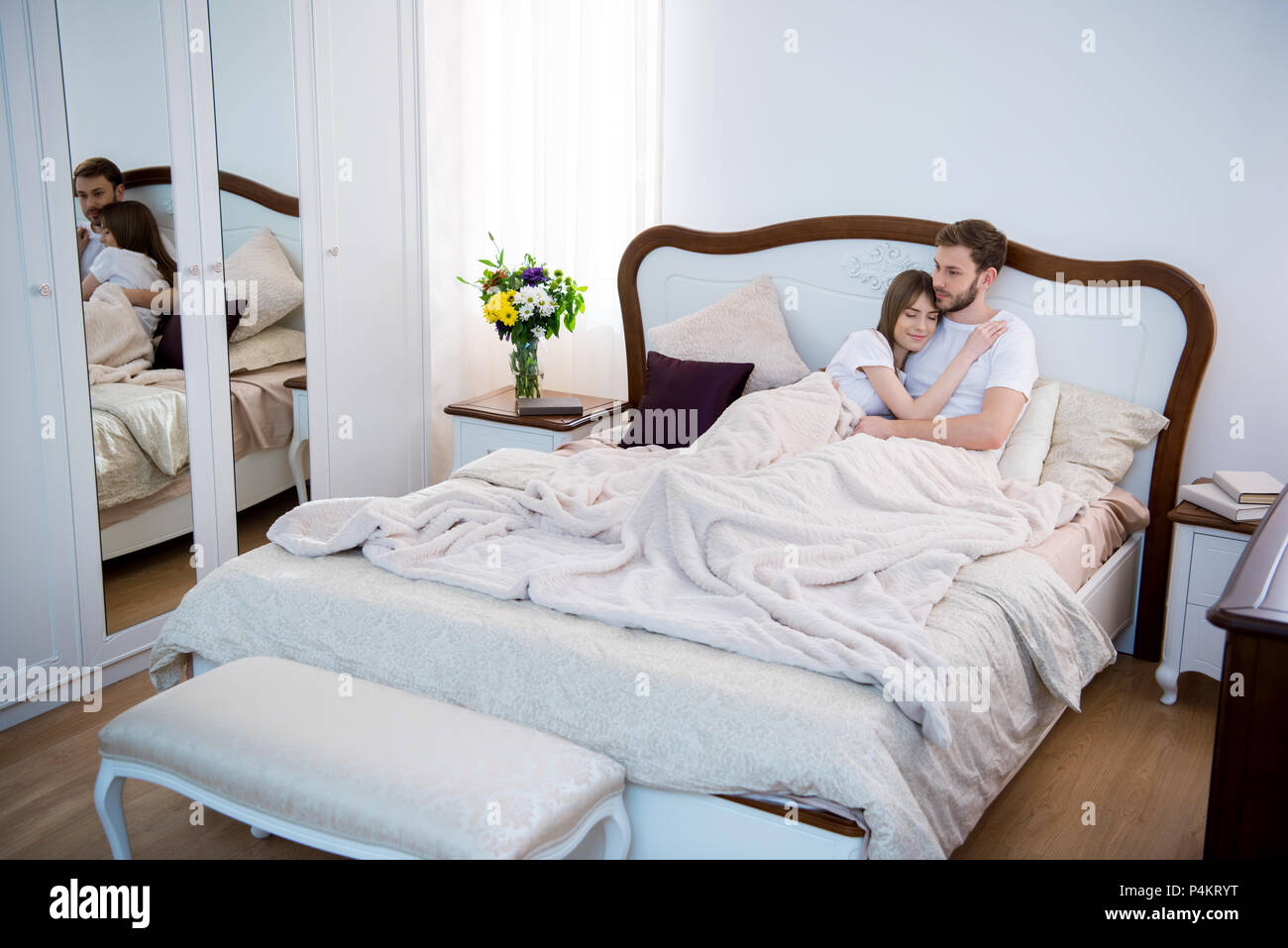 Couple lying on lit dans chambre à coucher confortable moderne Photo Stock  - Alamy