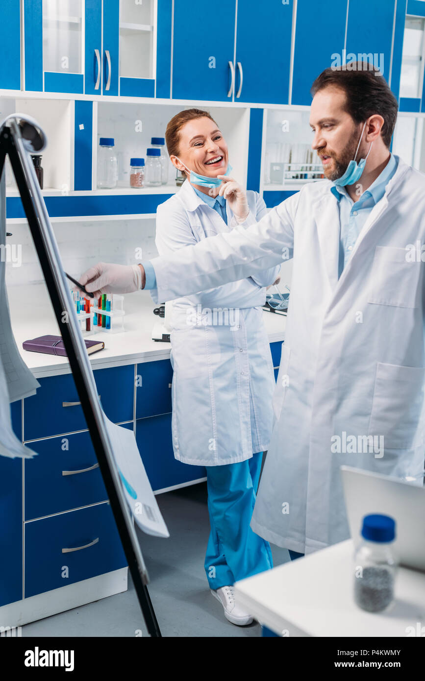 Chercheur scientifique en blouse blanche près de conseil pour avoir des  notes pendant le travail de discussion in lab Photo Stock - Alamy