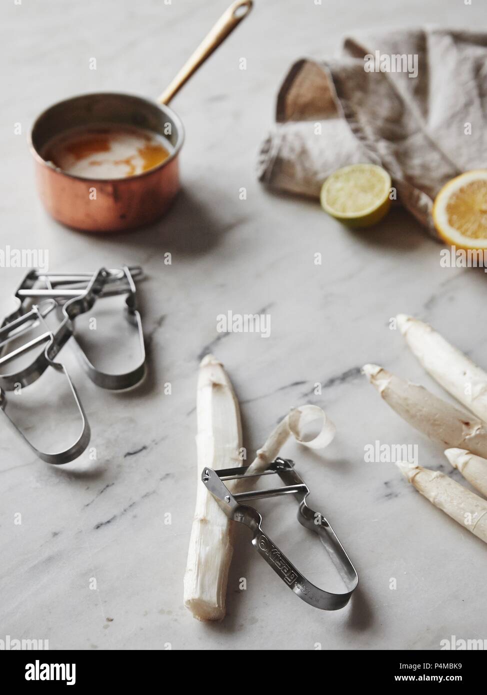 Les asperges blanches avec un couteau économe et une casserole de beurre brun Banque D'Images