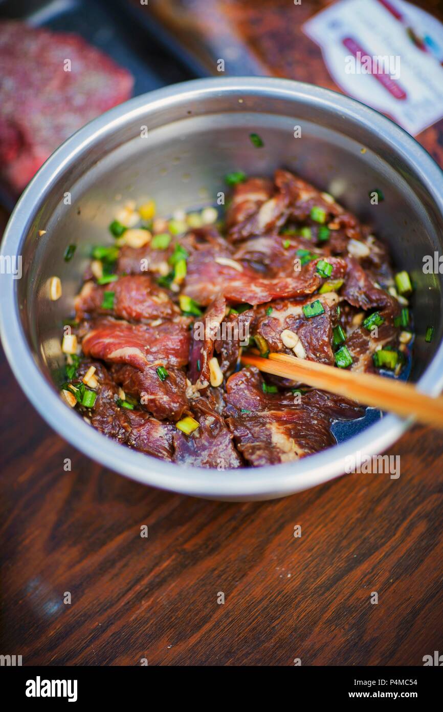 Le boeuf cru dans une marinade à l'ail Banque D'Images