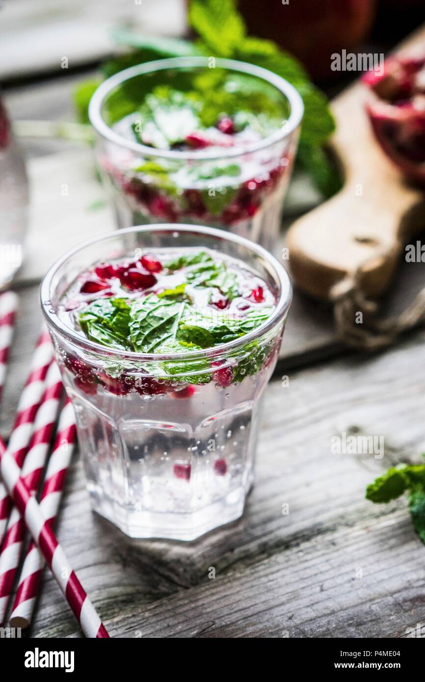Les boissons Detox avec de l'eau de citron, de menthe et de graines de grenade Banque D'Images