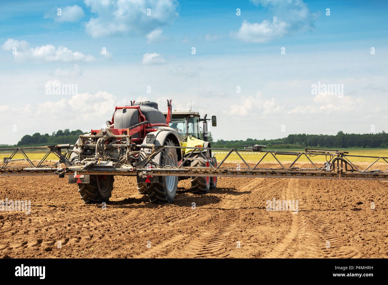 Tracteur avec pulvérisateur sur le terrain Banque D'Images