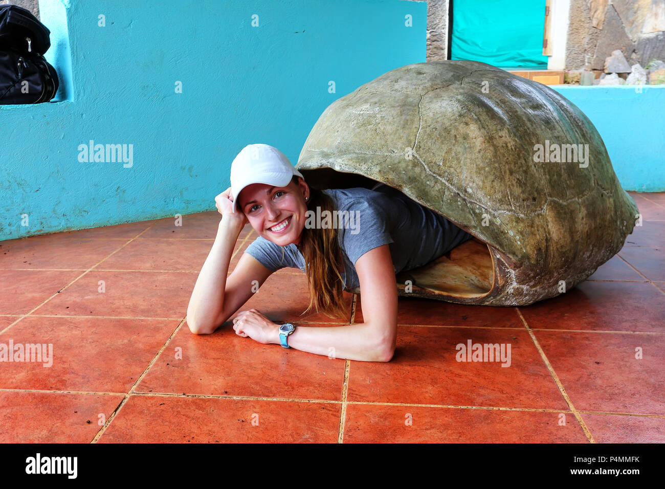 Jeune femme se trouvant à l'intérieur de l'écaille de tortue géante des Galapagos vide au sanctuaire sur l'île Santa Cruz, Parc National des Galapagos, Equateur. Banque D'Images