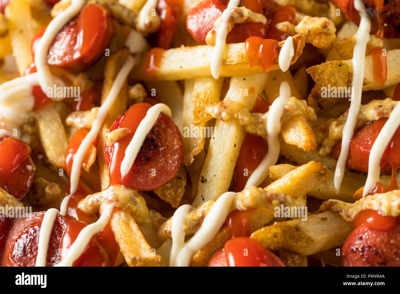 Péruvien fait maison Salchipapa frites avec Ketchup et Moutarde Mayo Banque D'Images