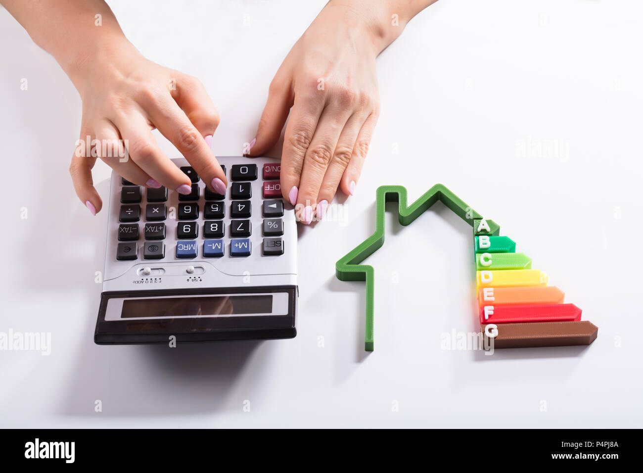 Close-up of a House montrant le taux d'efficacité énergétique en face de Businesswoman Using Calculator Banque D'Images