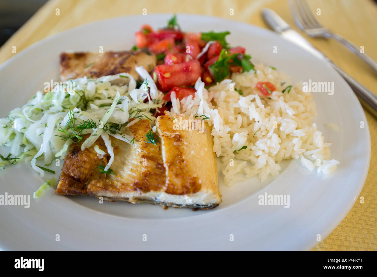 Le poisson frit avec du riz chou et les tomates sur la plaque Banque D'Images