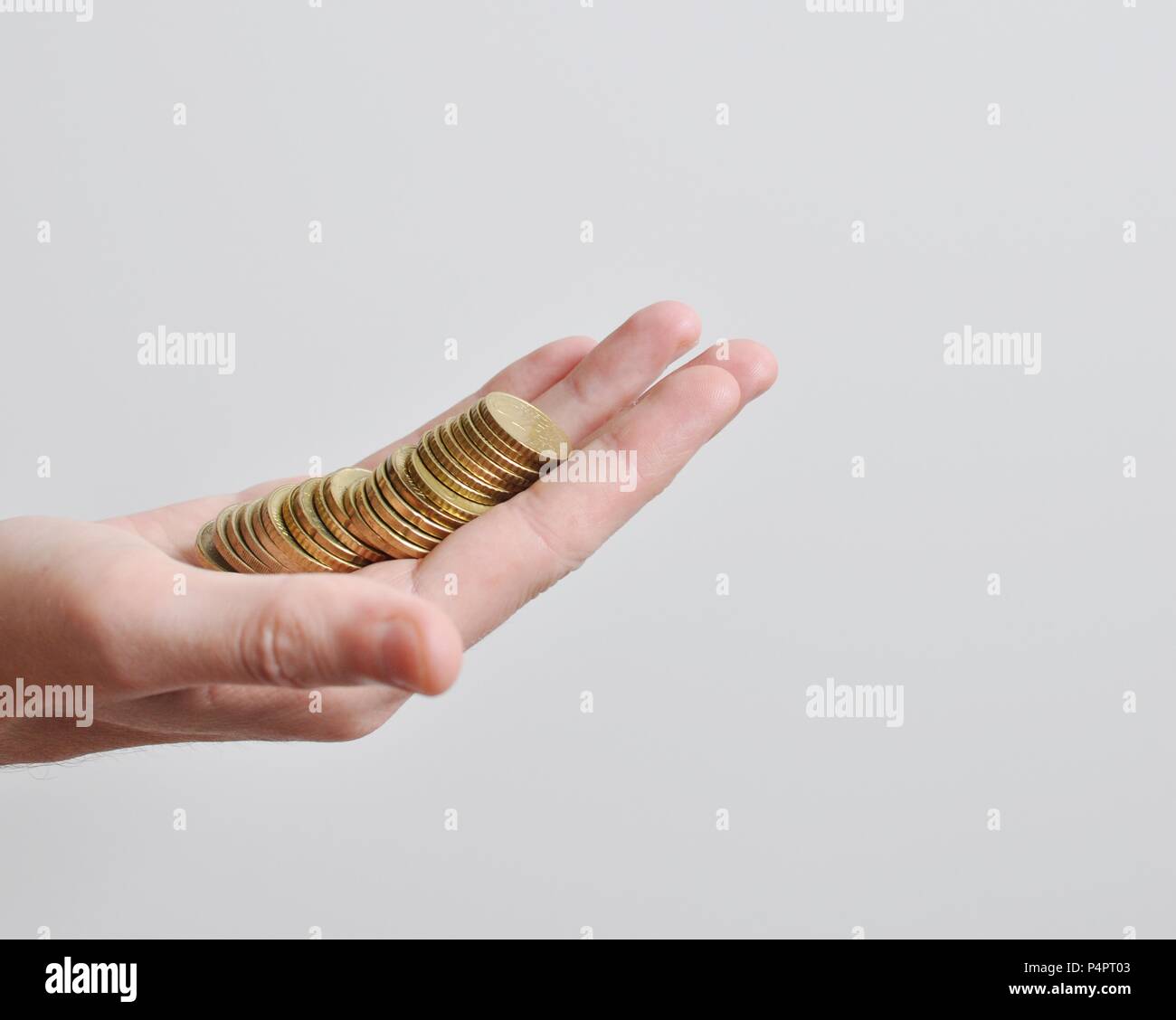 Une grande part d'un des hommes de la détention de monnaie, pièces d'or, sur fond blanc, isolée, vue latérale, copy space Banque D'Images