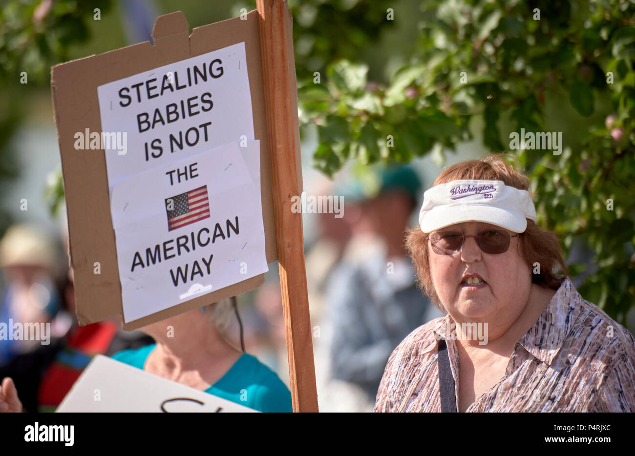 Une femme est titulaire d'un signe pendant un rassemblement à l'extérieur d'un centre de détention fédéral dans la région de Sheridan, de l'Oregon, pour protester contre la politique d'immigration du gouvernement américain. Banque D'Images