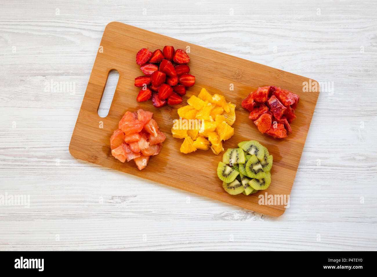 Matières premières fruits frais haché colorés disposés sur une planche ...