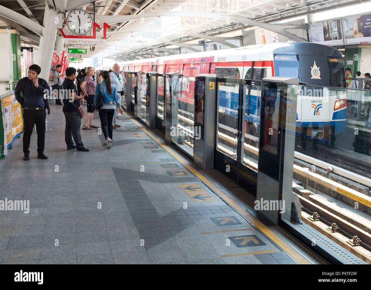 Les passagers qui attendent près de barrière de sécurité à la station de métro (BTS), Bangkok, Thaïlande, Asie. Banque D'Images