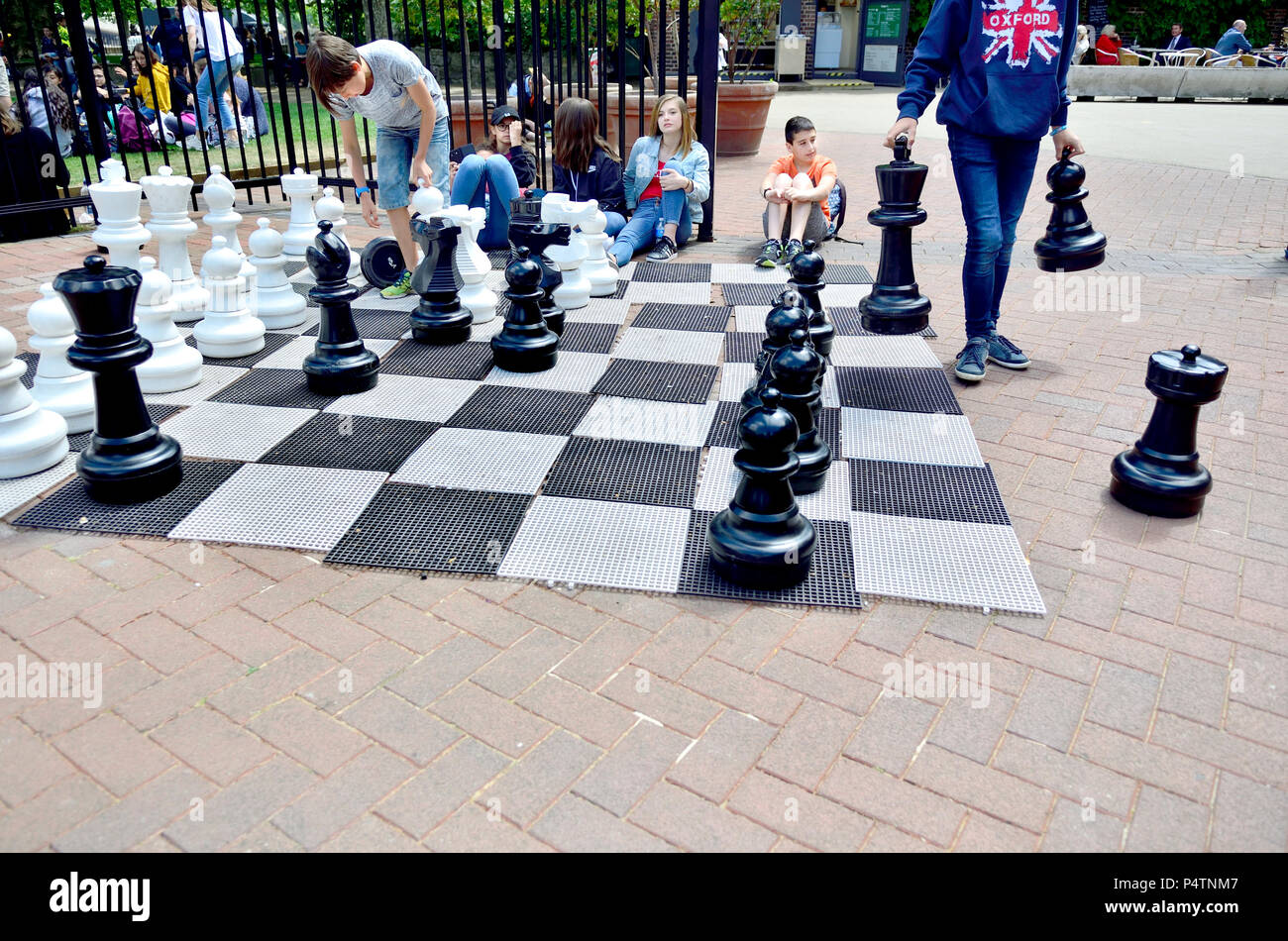 Enfants jouant aux échecs en plein air géant à Victoria Embankment Gardens, London, England, UK. Banque D'Images