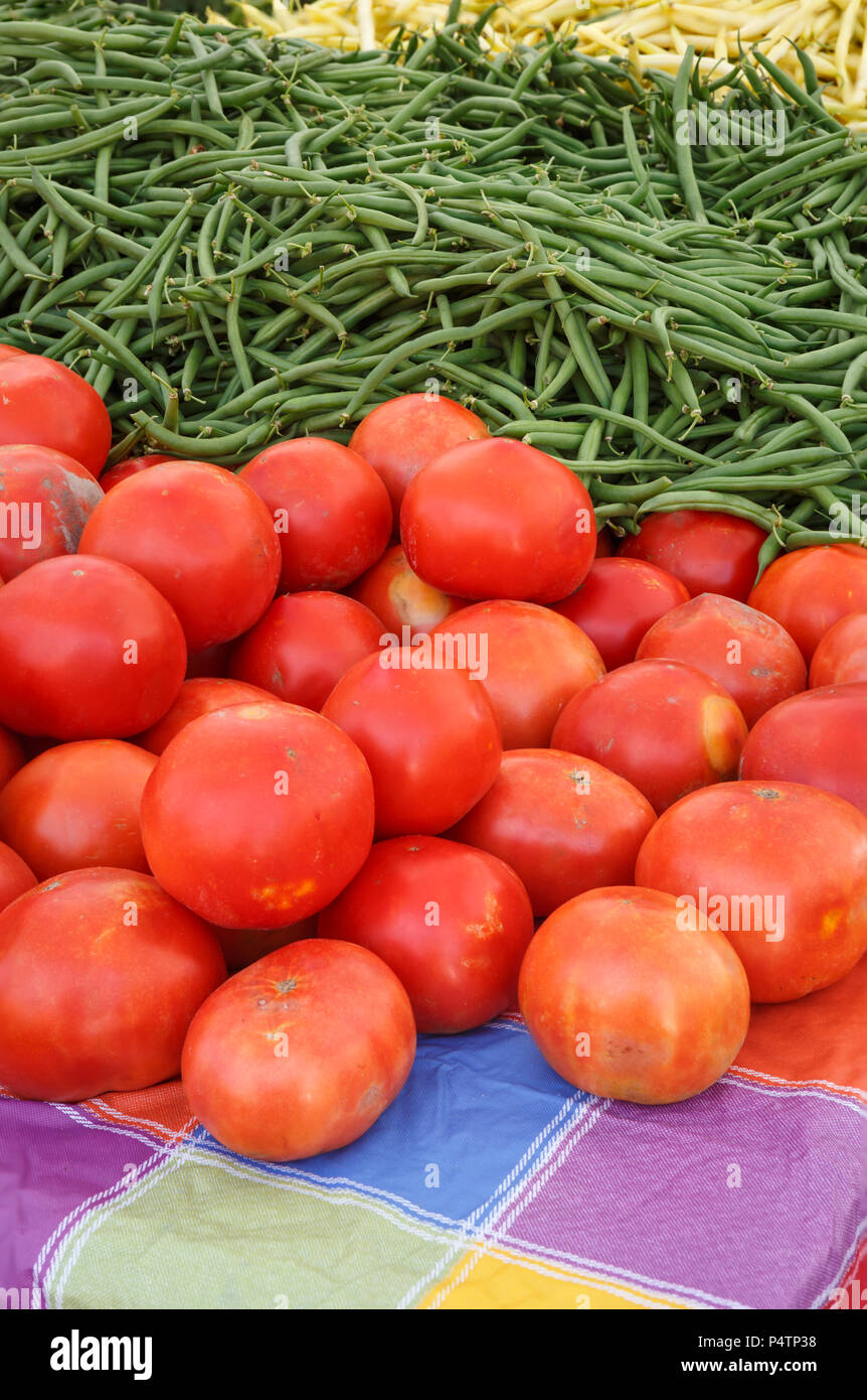 Les tomates fraîches cueillies et haricots au marché local Banque D'Images
