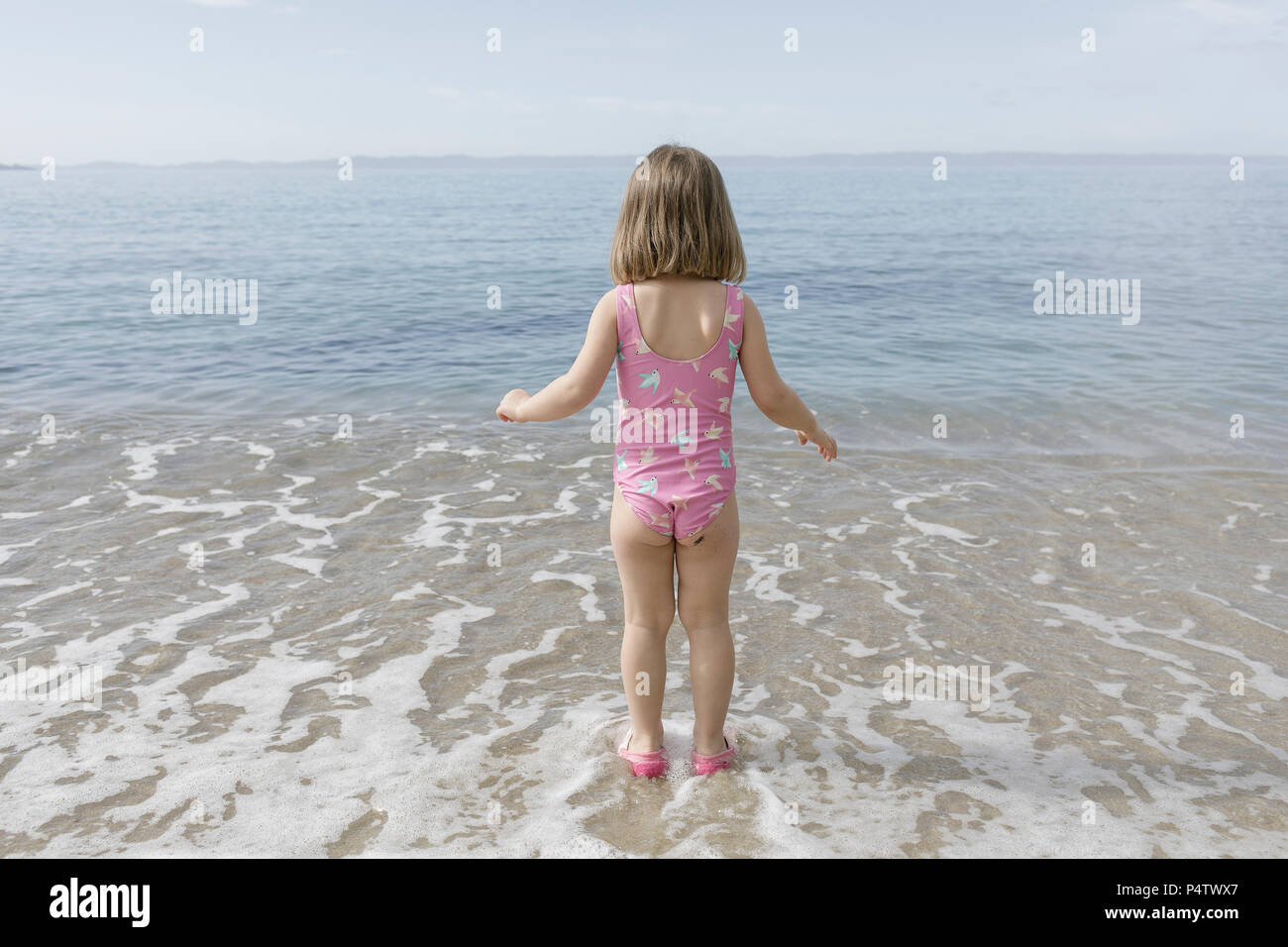 Vue de l'arrière petite fille debout à front de mer Banque D'Images