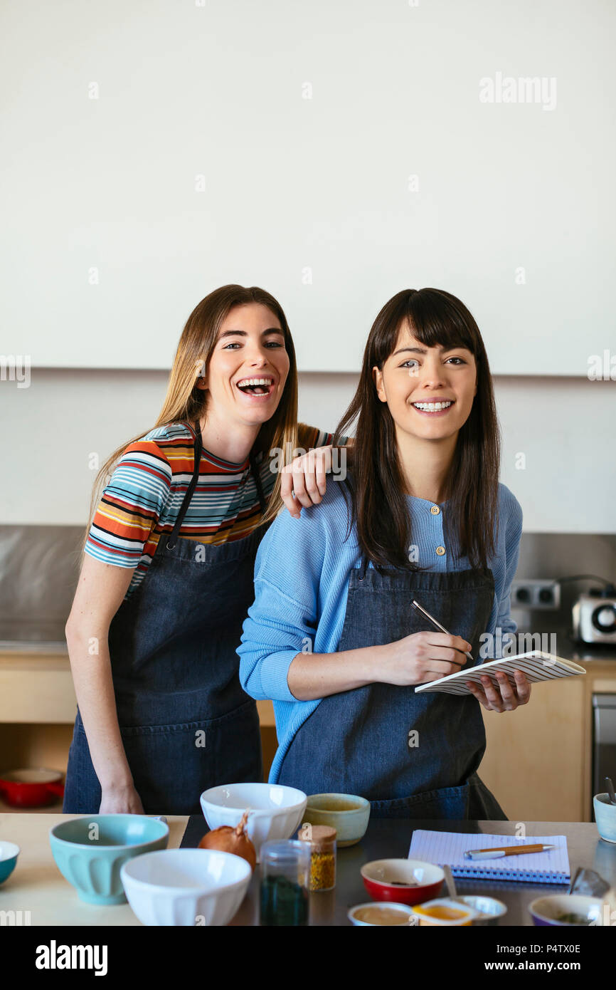 Portrait de deux femmes heureux avec un ordinateur portable dans la cuisine Banque D'Images